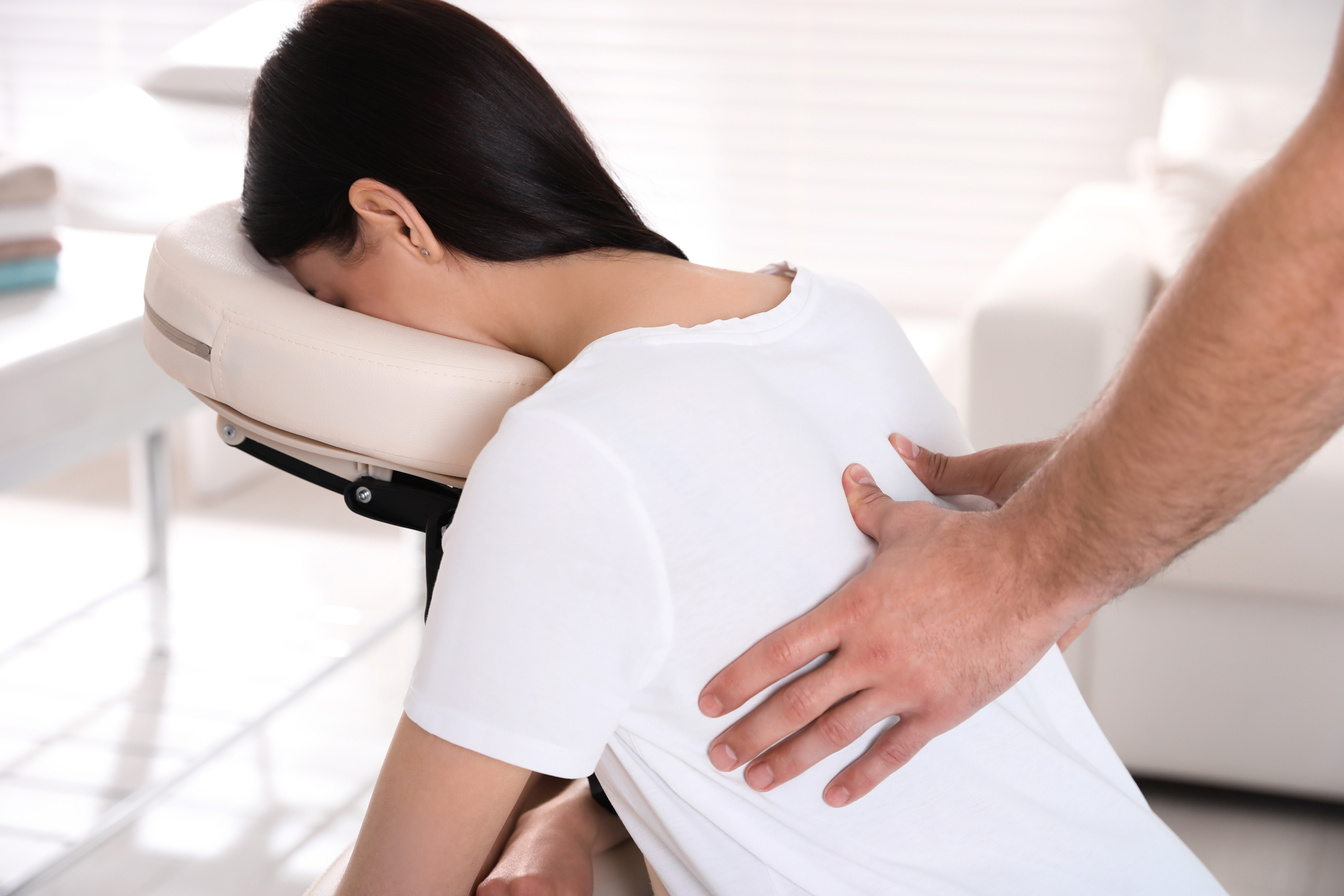 Woman Receiving Massage in Modern Chair Indoors